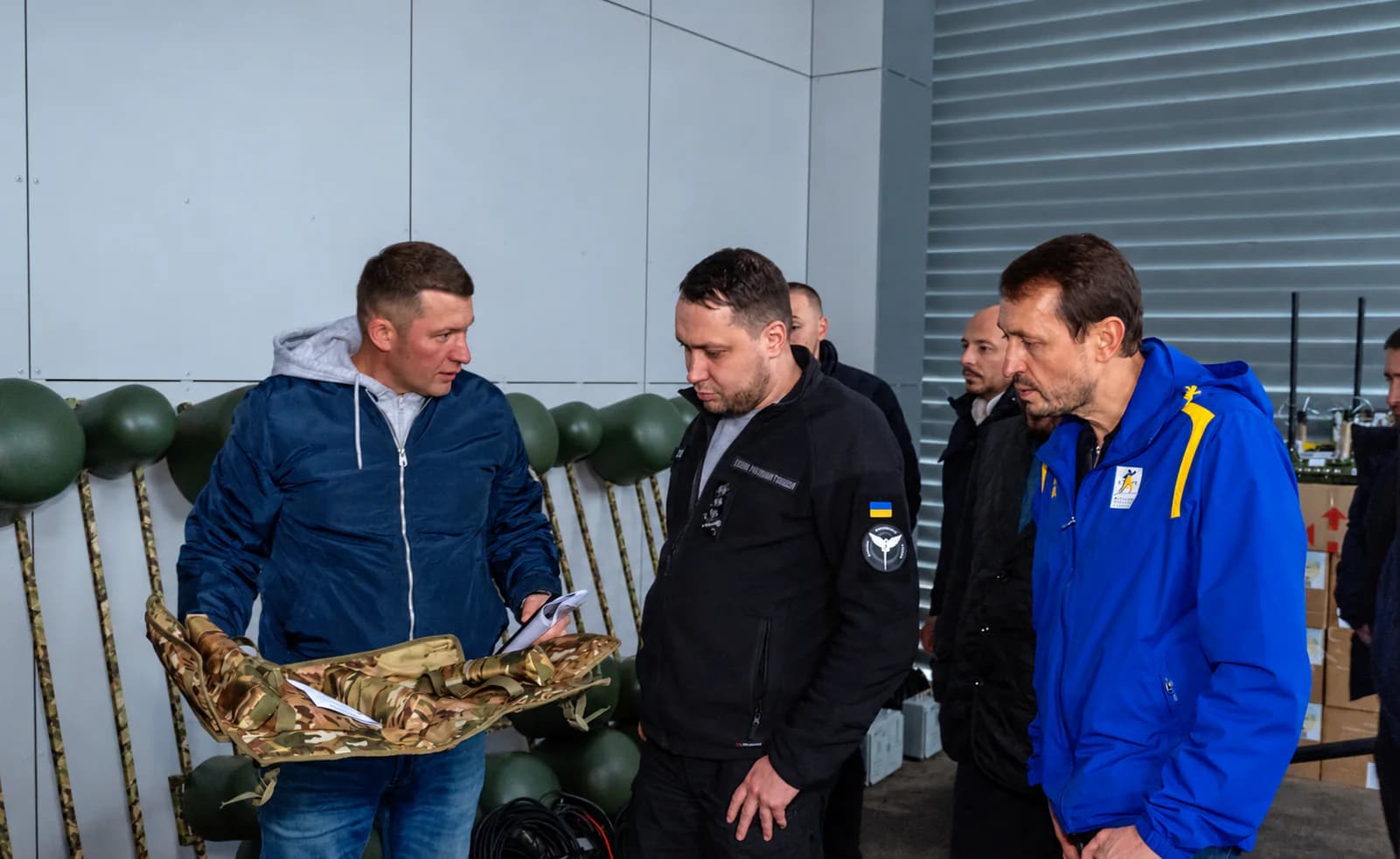 Представники розглядають маскувальний чохол у виставковому приміщенні