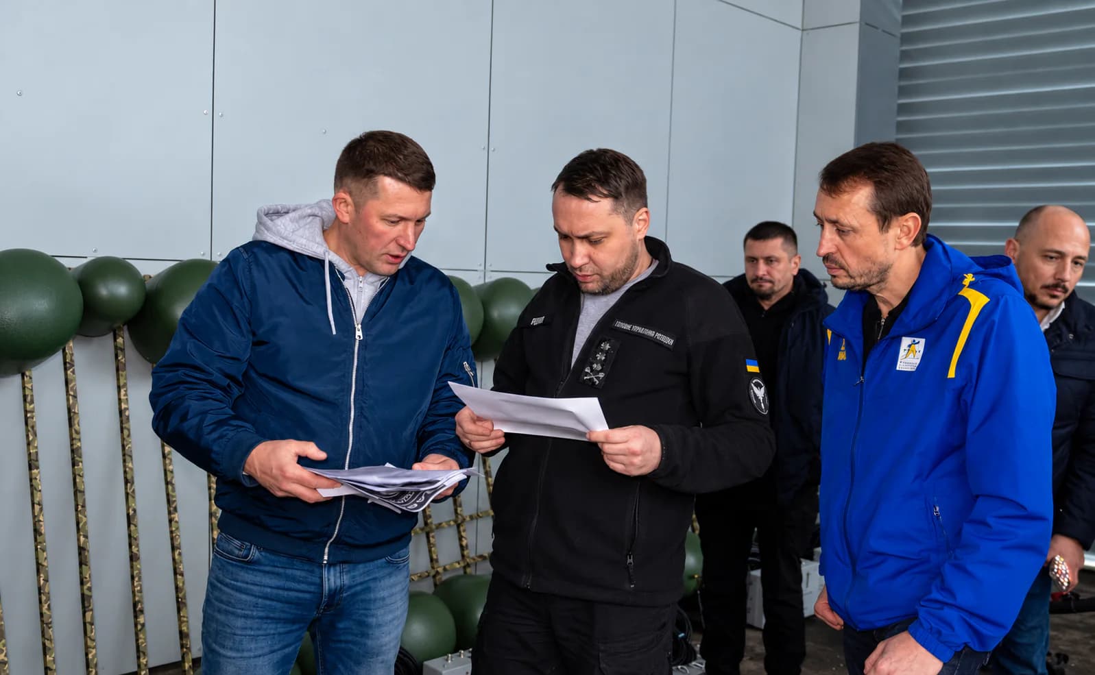 Учасники зустрічі переглядають матеріали поруч із маскувальним виробом